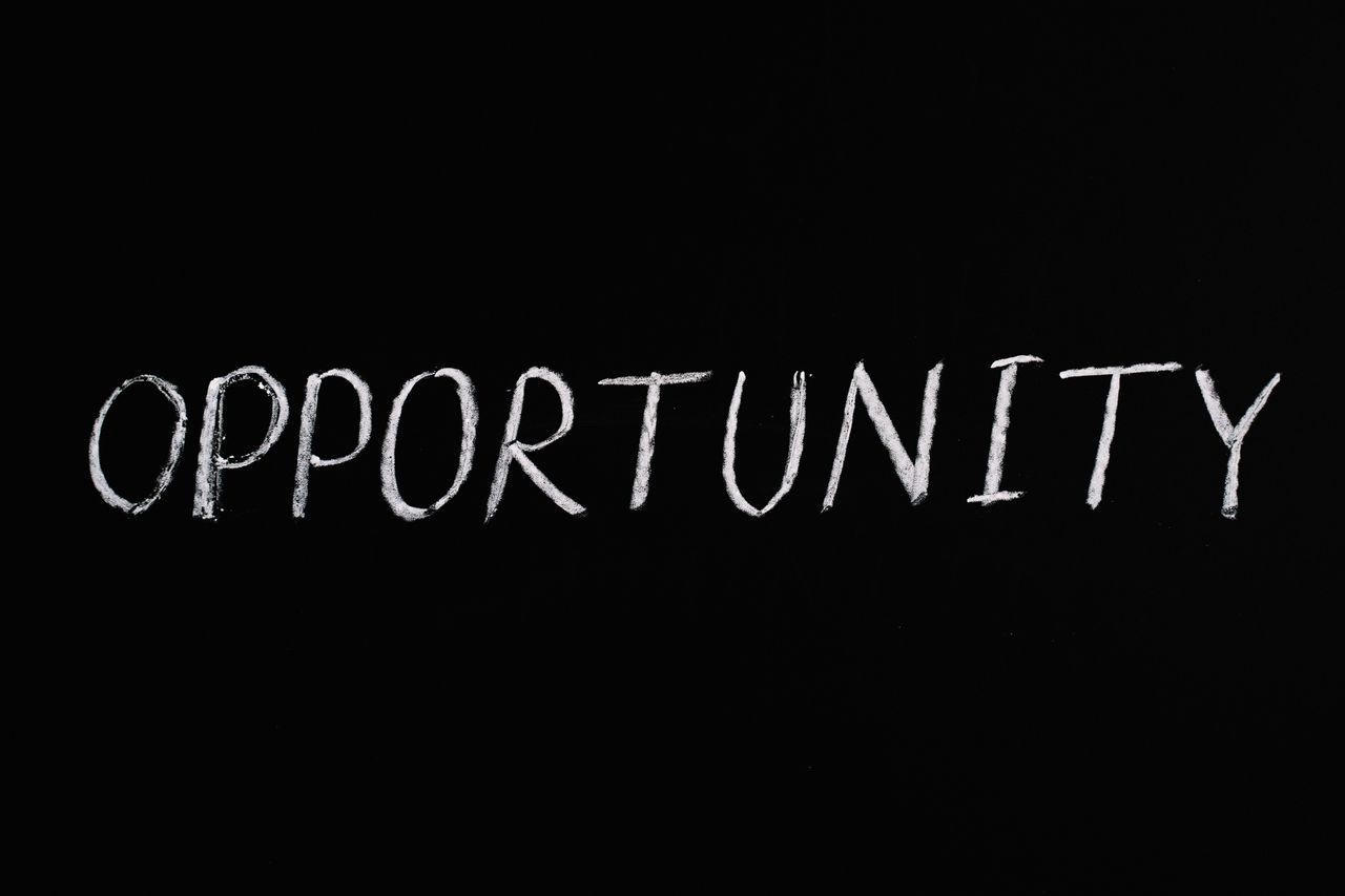 Word 'Opportunity' written in chalk on a black chalkboard, symbolizing new possibilities.